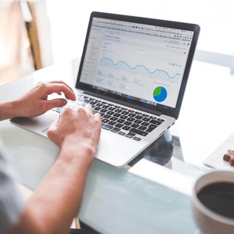 Person analysing graphs and charts on a laptop, highlighting data insights, efficiency, and financial management.